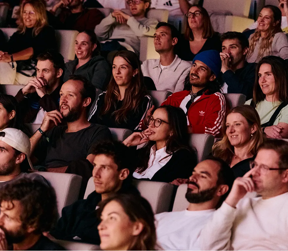Audience members watching presentation in auditorium