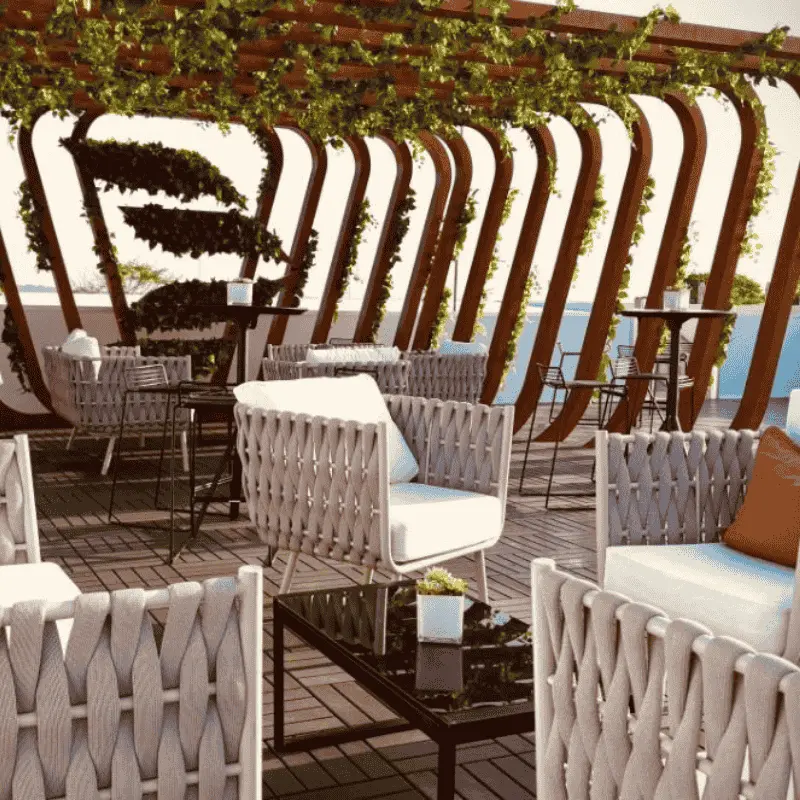 Modern rooftop lounge with woven chairs and pergola