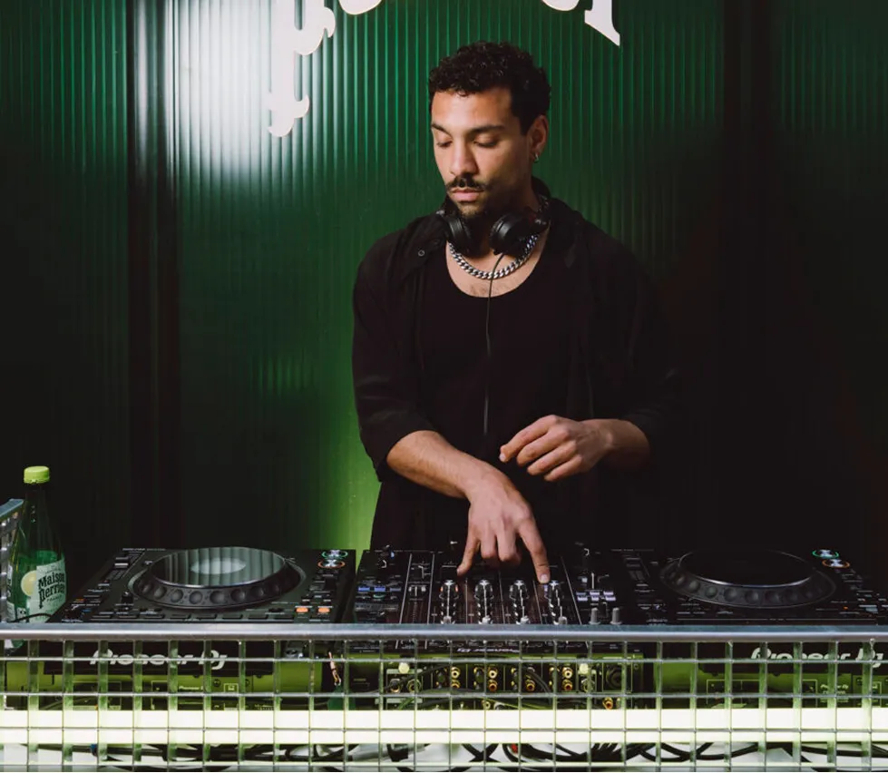 DJ mixing music on controller in green studio