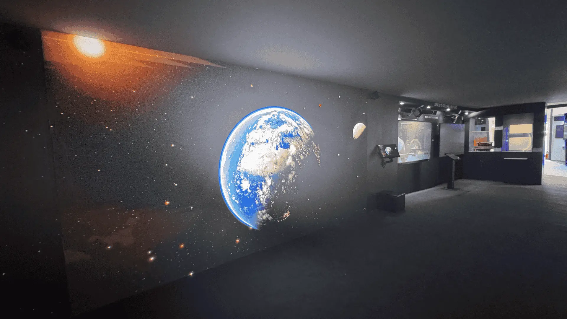 Space-themed museum exhibit with large Earth display
